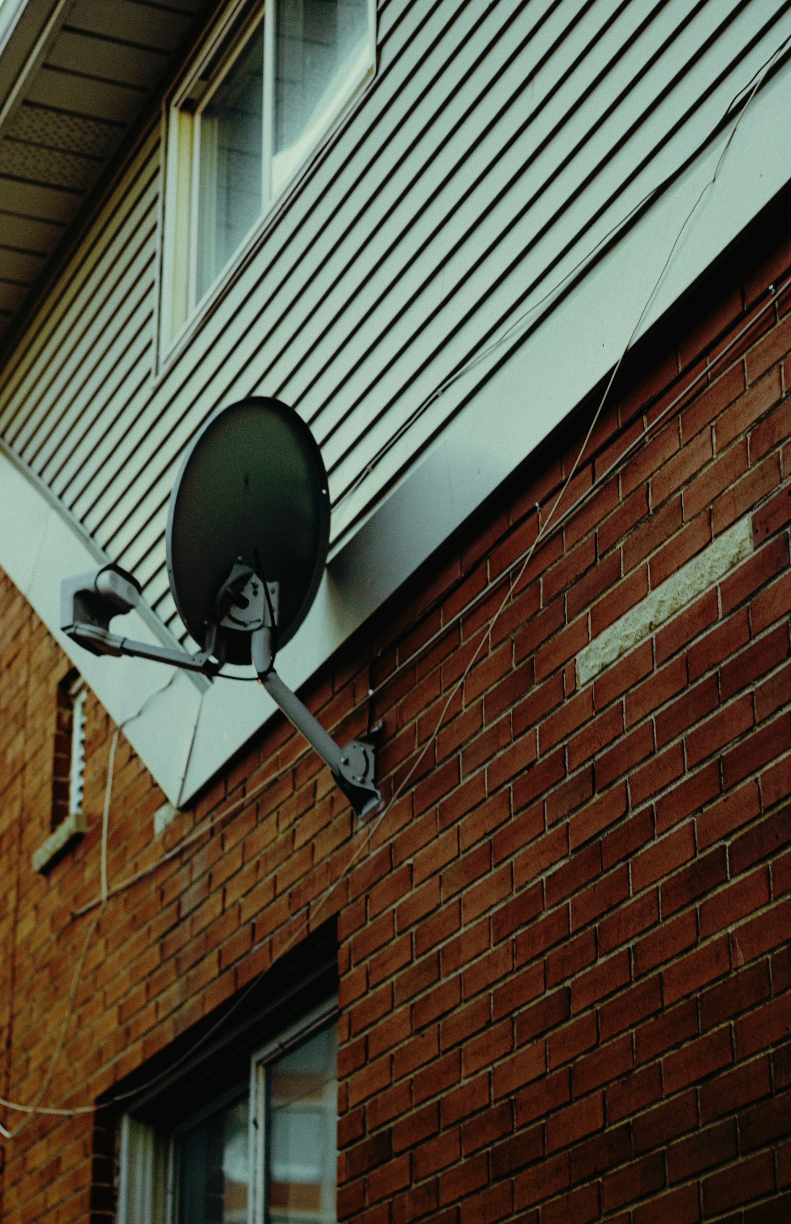 Satellite dish installed on a residential brick wall